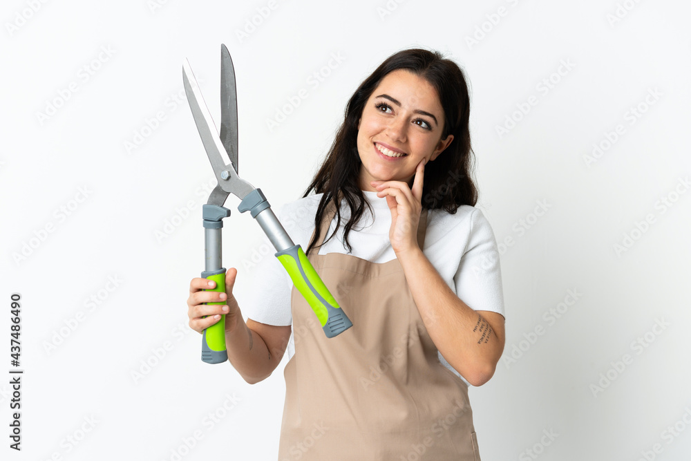 Young caucasian woman holding a plant isolated on white background thinking an idea while looking up Young caucasian woman holding a plant isolated on white background thinking an idea while looking up