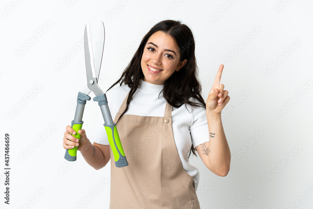 Young caucasian woman holding a plant isolated on white background showing and lifting a finger in sign of the best Young caucasian woman holding a plant isolated on white background showing and lifting a finger in sign of the best