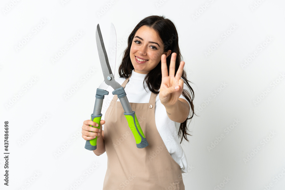 Young caucasian woman holding a plant isolated on white background happy and counting three with fingers Young caucasian woman holding a plant isolated on white background happy and counting three with fingers