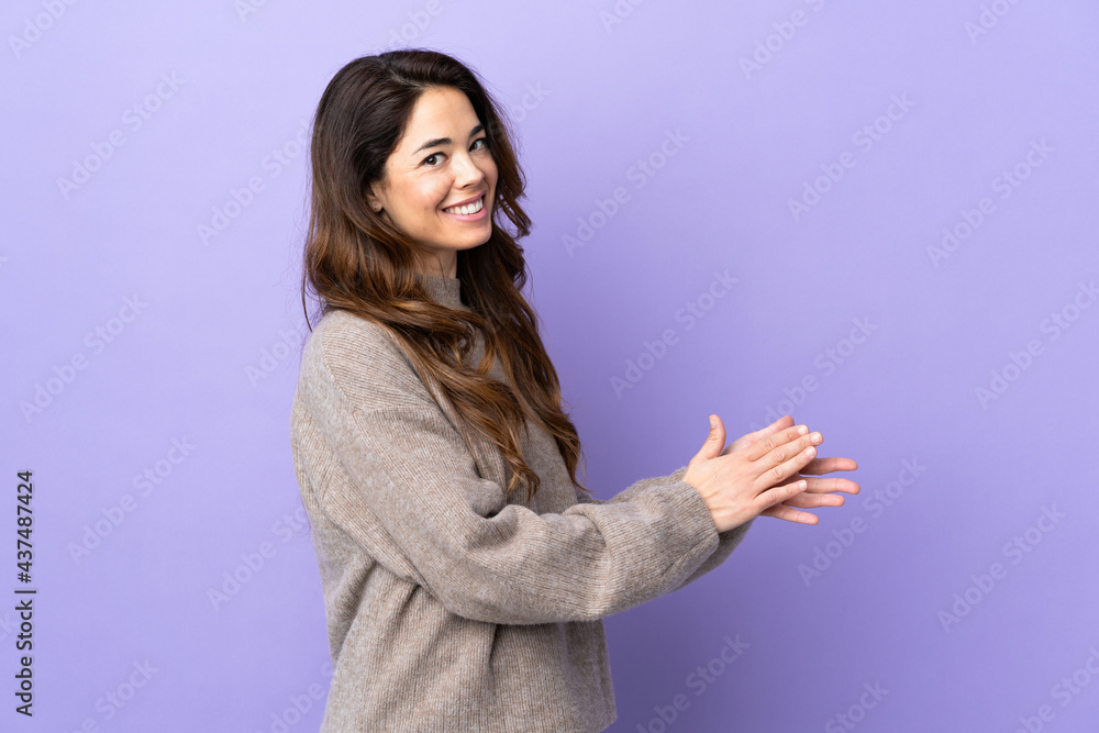 Woman over isolated purple background applauding Woman over isolated purple background applauding