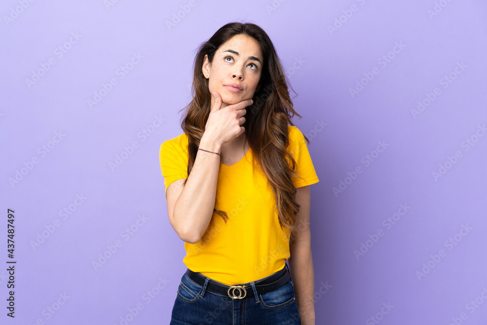 Woman over isolated purple background having doubts Woman over isolated purple background having doubts