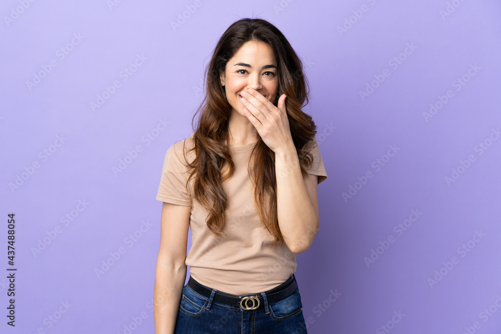 Woman over isolated purple background happy and smiling covering mouth with hand Woman over isolated purple background happy and smiling covering mouth with hand