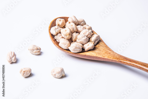 a spoon of dried chickpeas against white background