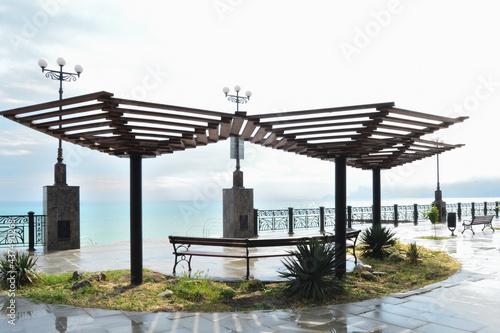 Empty benches in the gazebo on the embankment after the rain in the resort town Sudak, Crimea.