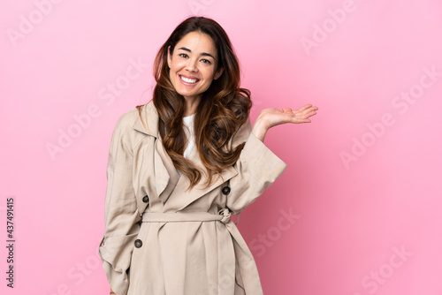 Woman over isolated background holding copyspace imaginary on the palm to insert an ad © luismolinero