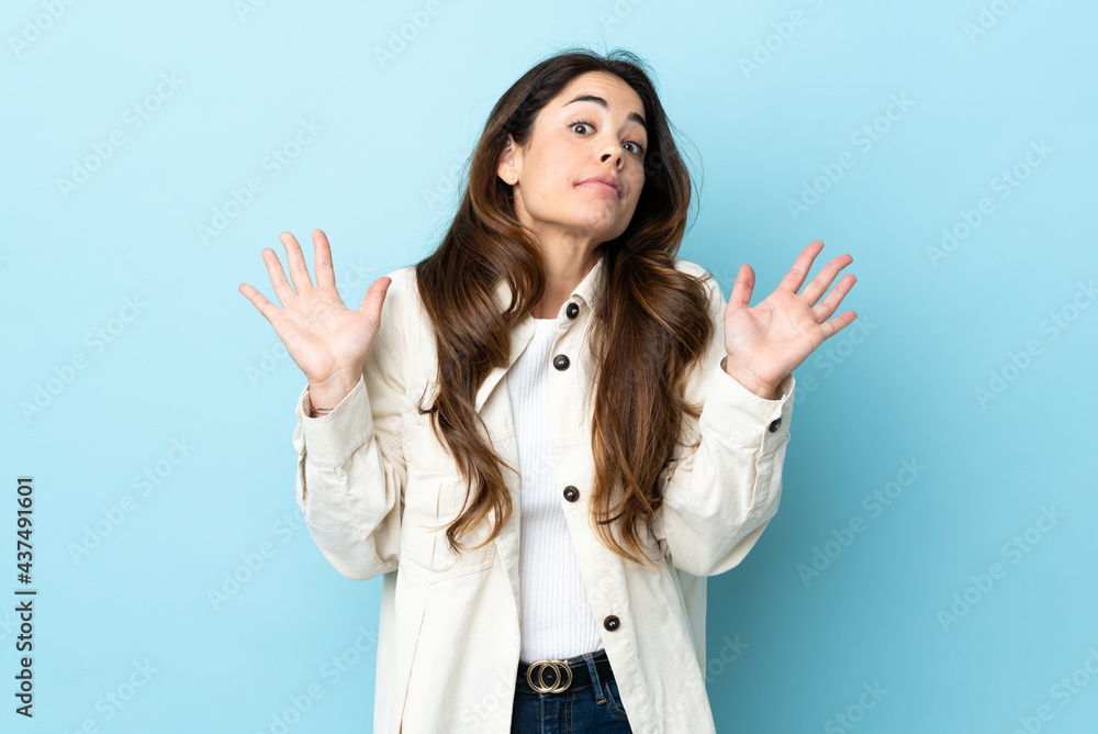 Woman over isolated background making doubts gesture Woman over isolated background making doubts gesture