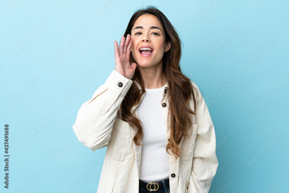 Woman over isolated background shouting with mouth wide open Woman over isolated background shouting with mouth wide open
