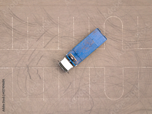 Blue tow truck wrecker on empty parking. Aerial top down drone shot.