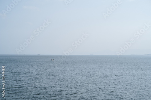 雄大な桜島を背景に錦江湾の鹿児島港と桜島港フェリーターミナルを結ぶ桜島フェリーからの眺め © mm