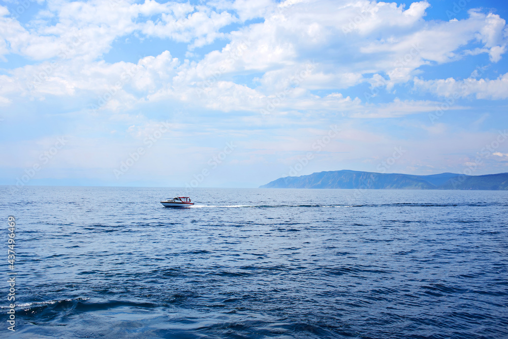 View of a boat in motion on water. Lake Baikal on a summer day. Listvyanka village. View of a boat in motion on water. Lake Baikal on a summer day. Listvyanka village.