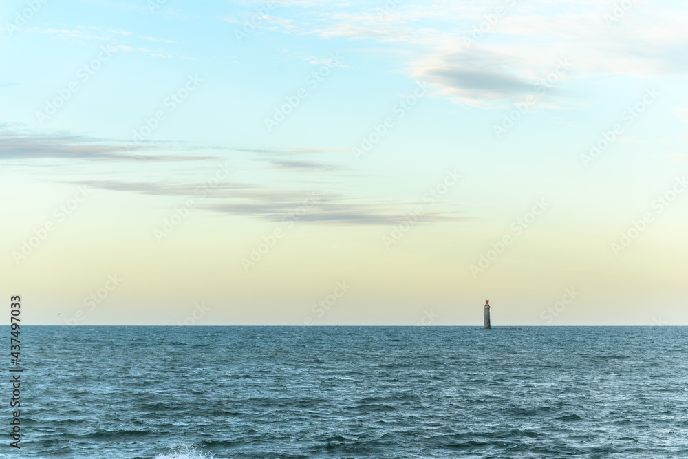 The Barges lighthouse on the horizon on the Atlantic Ocean off the coast of Sables d'Olonne.