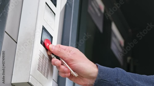 Male using intercom at residential building entrance. opens electronic code lock. man hand entering security system code, pressing button with index finger intercom device entrence door. photo