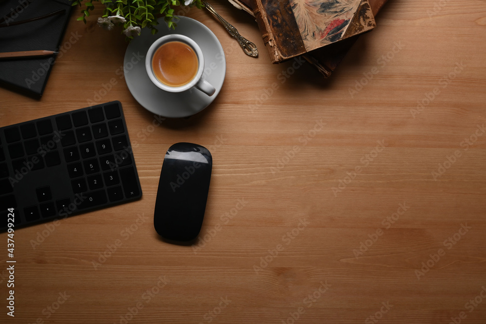 Modern workplace with keyboard, notebook, coffee cup and plant on wooden background. Modern workplace with keyboard, notebook, coffee cup and plant on wooden background.