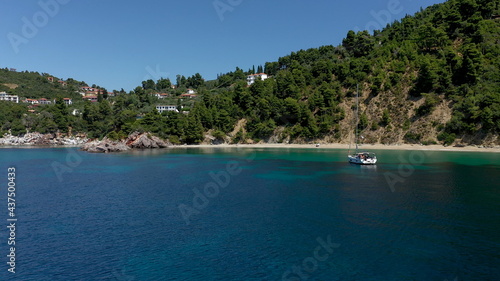 Drone aerial view of tourists enjoying a paradise luxury Yacht trip around Skopelos island, Greece, Aegean Sea, Europe.