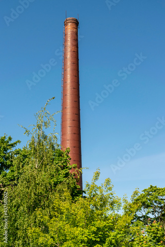 Brick chimney of a city boiler house in summer.