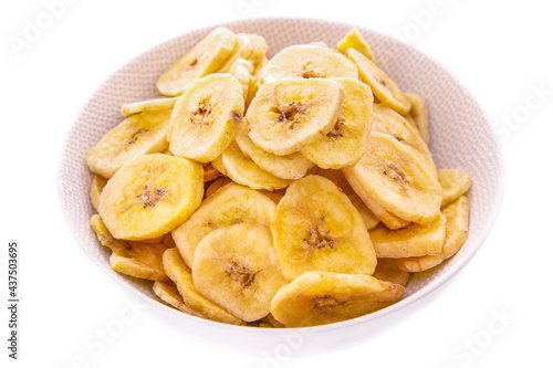 Banana chips in a white plate on a white background, isolated products