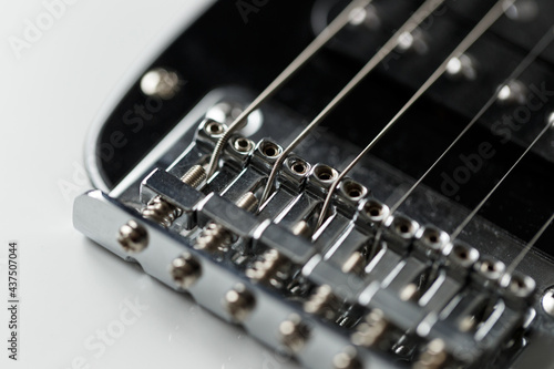 Electrical guitar bridge and metal strings closeup. Electric guitar black and white color, detail. Music instruments. Concept international music day. Macro