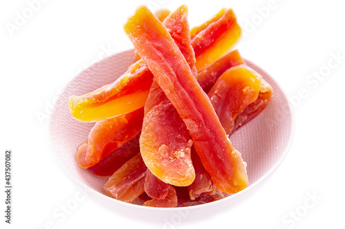 Dry papaya sticks in a light plate on a white background.isolated products
