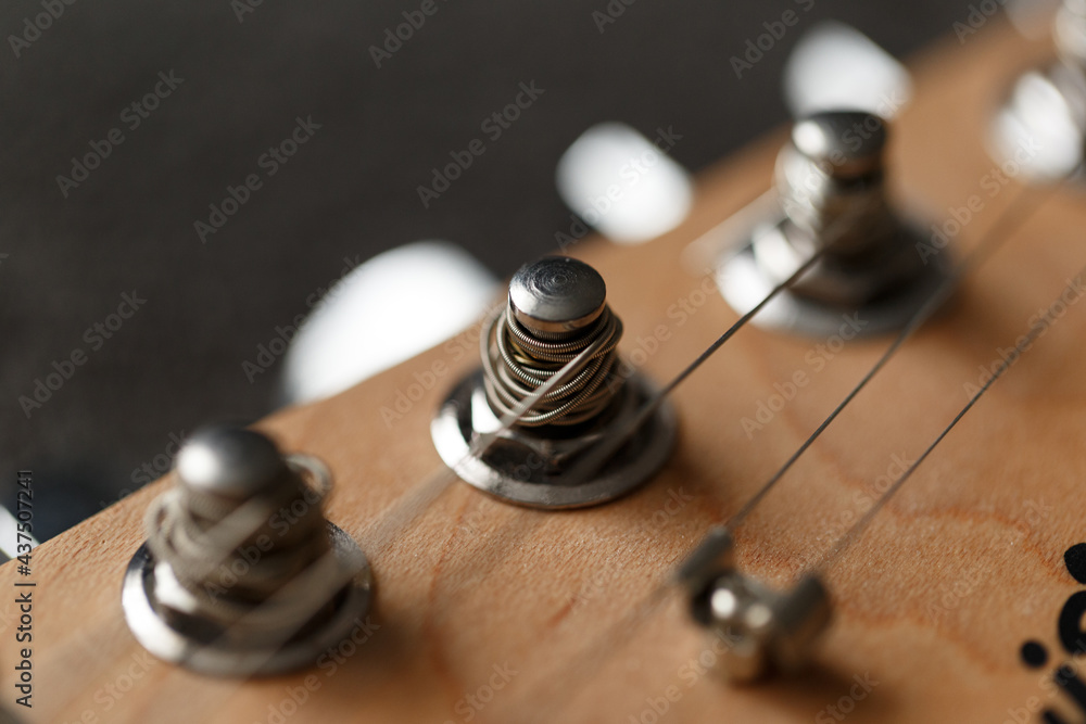 Electrical guitar headstock, machine heads and metal strings closeup