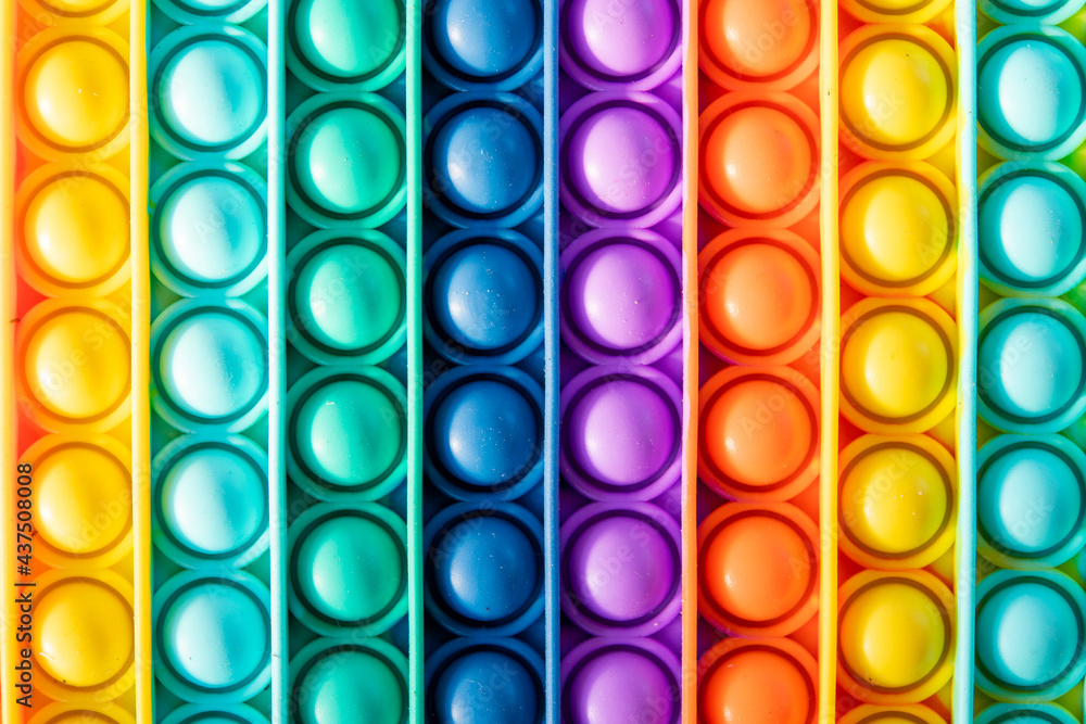 Bright rainbow toy antistress for children and adults on a colorful background. Flexible sensory antistress toy - popit. Bright rainbow toy antistress for children and adults on a colorful background. Flexible sensory antistress toy - popit.