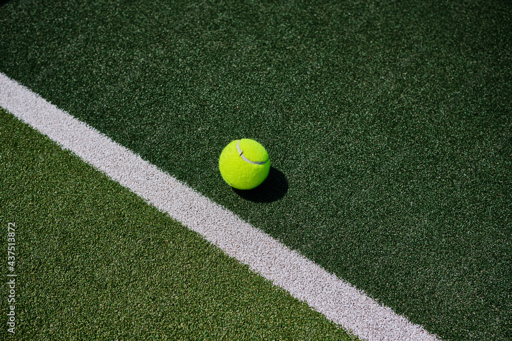 Tennis ball on artificial court.
