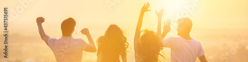 The four people dancing on the background of the bright sunset
