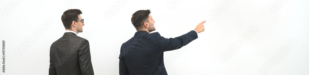 The two businessmen with bags gesture on the white wall background The two businessmen with bags gesture on the white wall background