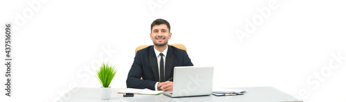 The happy businessman sitting at the desktop on the white background