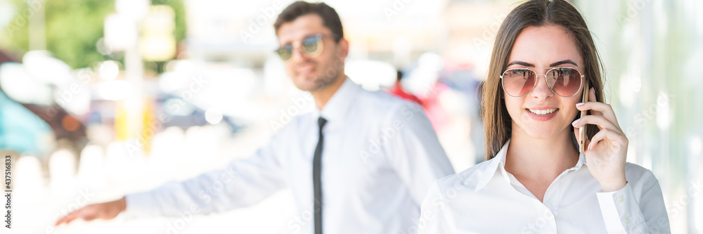 The businesswoman hold a cup of coffee and phone near the man The businesswoman hold a cup of coffee and phone near the man