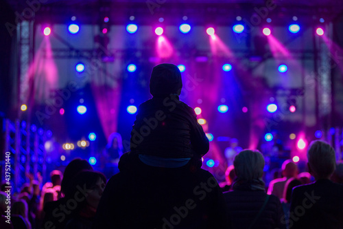 Concert attendees in the dark with a lighted concert stage.