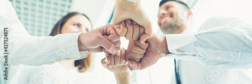 Obraz na plátně The four business people gesture with a fist