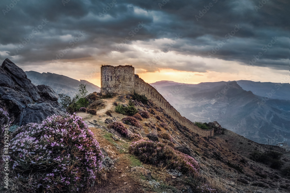 Dramatic sunrise at the ancient fortress on the top of the mountain. The Gunib fortress is a historical monument of Dagestan.