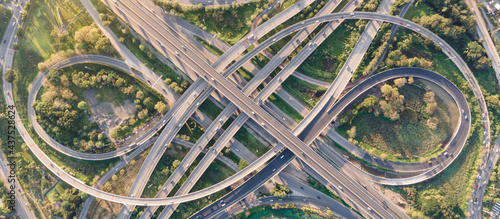 Aerial view of road interchange or highway intersection with busy urban traffic speeding on the road. Junction network of transportation taken by drone. photo
