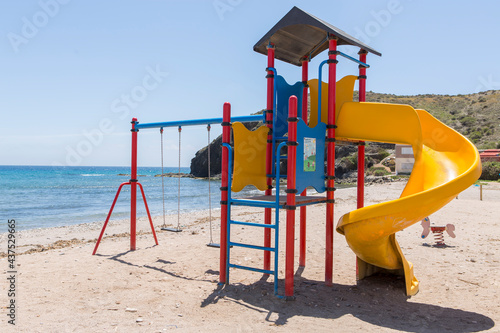 Children's playground with slide, swings and climbing area, located on the shore of the Spanish beach of Puntas de Calnegre. photo