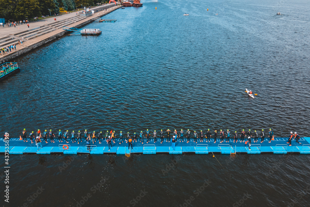 Triathlon swimming contest in lake swimmers competition aerial drone photo.  Group of swimmers during a competition in the sea