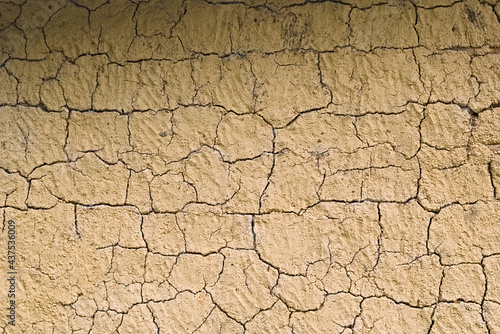 Mud wall texture background. Cracks in a mud wall. Yellow wall. Wall made with bahareque