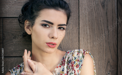  beautiful brunette posing on a wooden wall background