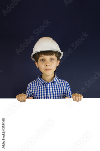 Happy little boy in the helmet against white banner.