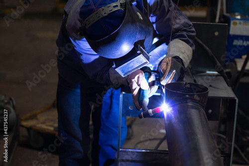Skillful welders weld steel in the factory. Construction site metal welder. © niwat