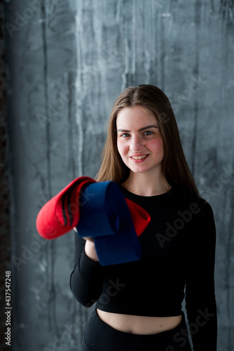 Beautiful happy girl in sports uniform holding elastic bands for workouts in her hands smiling © DmitryStock