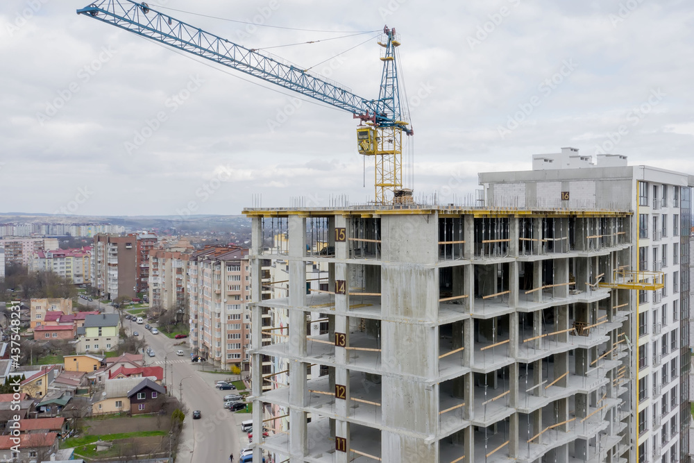 Aerial view of concrete frame of tall apartment building under construction in a city. Aerial view of concrete frame of tall apartment building under construction in a city.