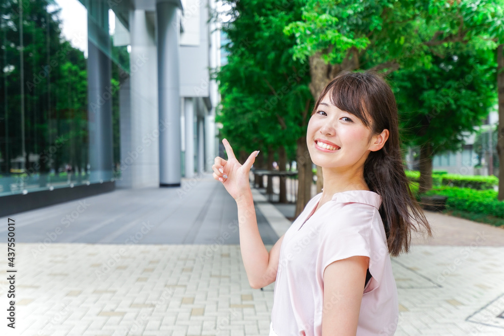 都会で指差す女性 都会で指差す女性