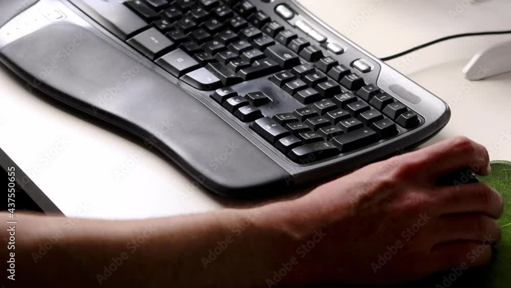 Business man or professional programmer typing on ergonomic keyboard with ergonomic mouse in home office workplace with modern computer equipment from home with European hands of a male person closeup Business man or professional programmer typing on ergonomic keyboard with ergonomic mouse in home office workplace with modern computer equipment from home with European hands of a male person closeup