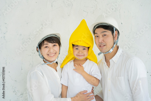 防災頭巾をかぶる子供とヘルメットを装着する親