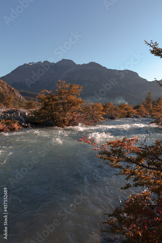 Landscape with River and Mountains. Sunrise in the Andes Mountans. Argentina. Fitz Roy National Park. Dark Outline of Mountain on a Blue Sky Background.