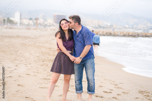 young beautiful and happy mixed ethnicity couple of Asian woman and Caucasian man relaxed and cheerful walking playful on beach enjoying love and romantic holidays
