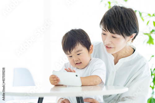 スマートフォンの画面を見る子供とお母さん