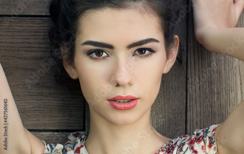  beautiful brunette posing on a wooden wall background