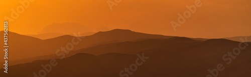 Panorama of mountain ridges silhouettes at sunset