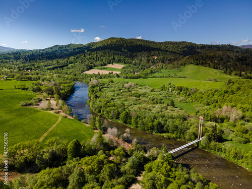 Fototapeta Naklejka Na Ścianę i Meble -  Suspension Bridge Over River San in Bieszczady Mountains. Drone View